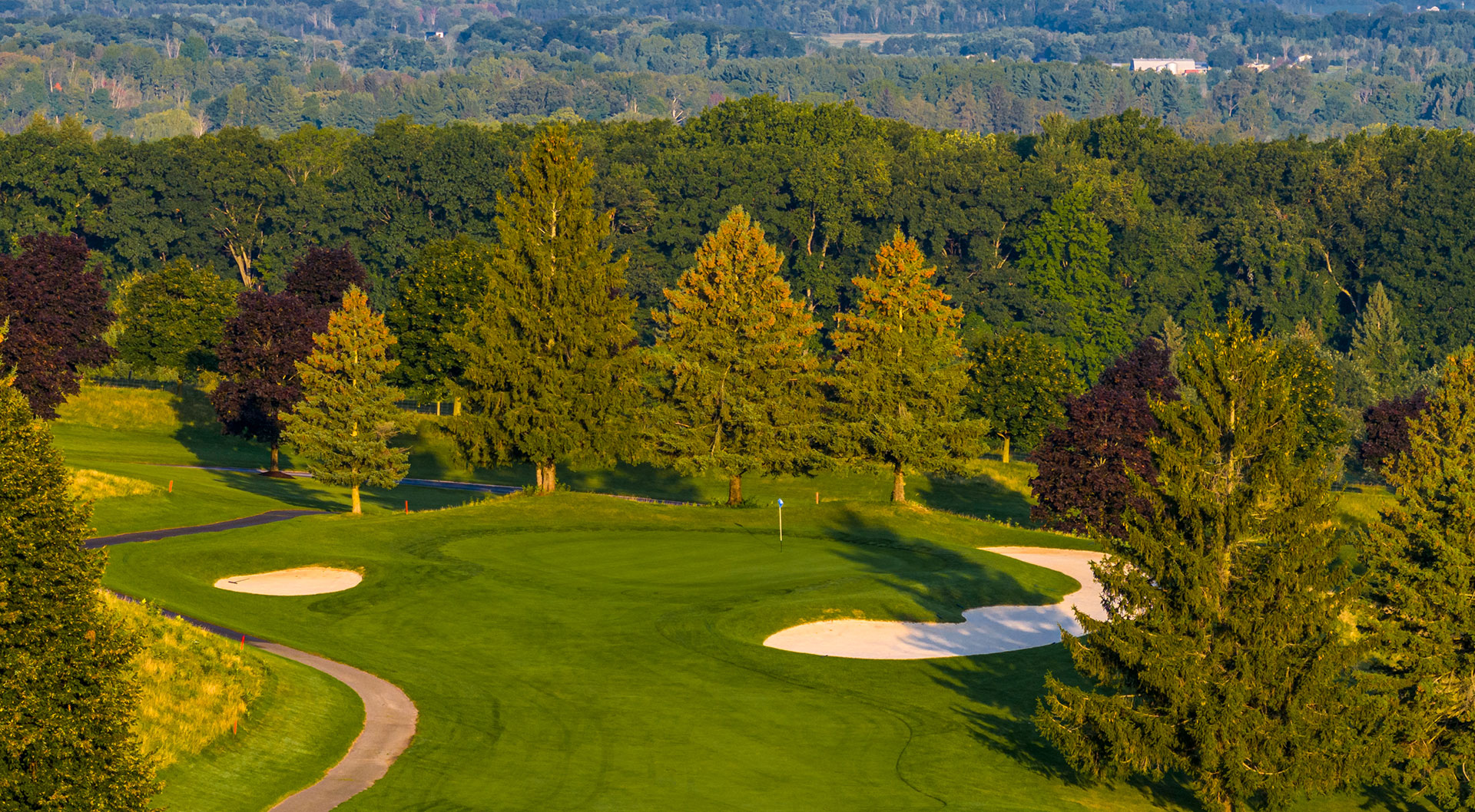 Peninsula Lakes Golf course with bunkers and tees, surrounded by lush greenery